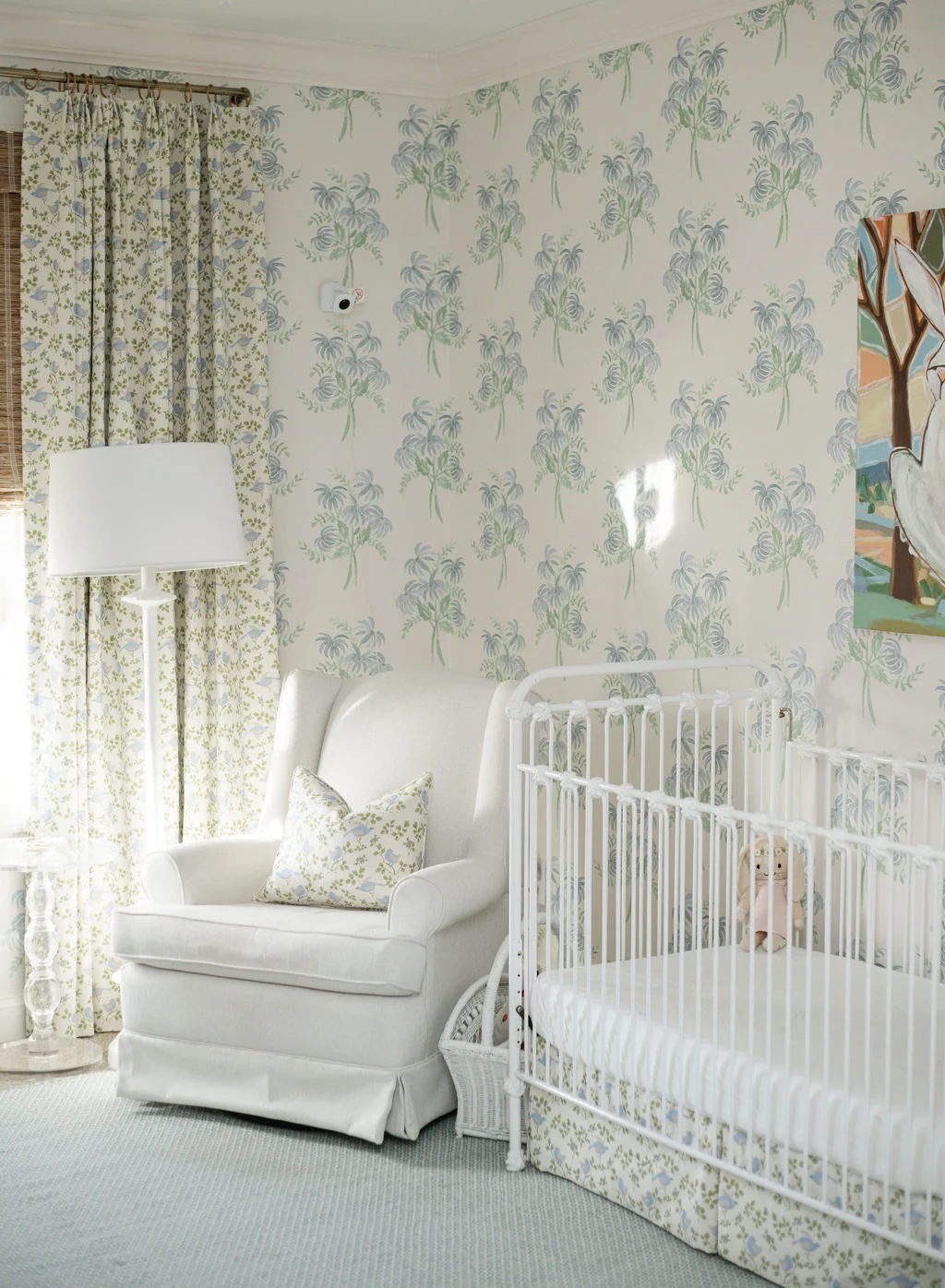 white nursery with green curtains floral wallpaper
