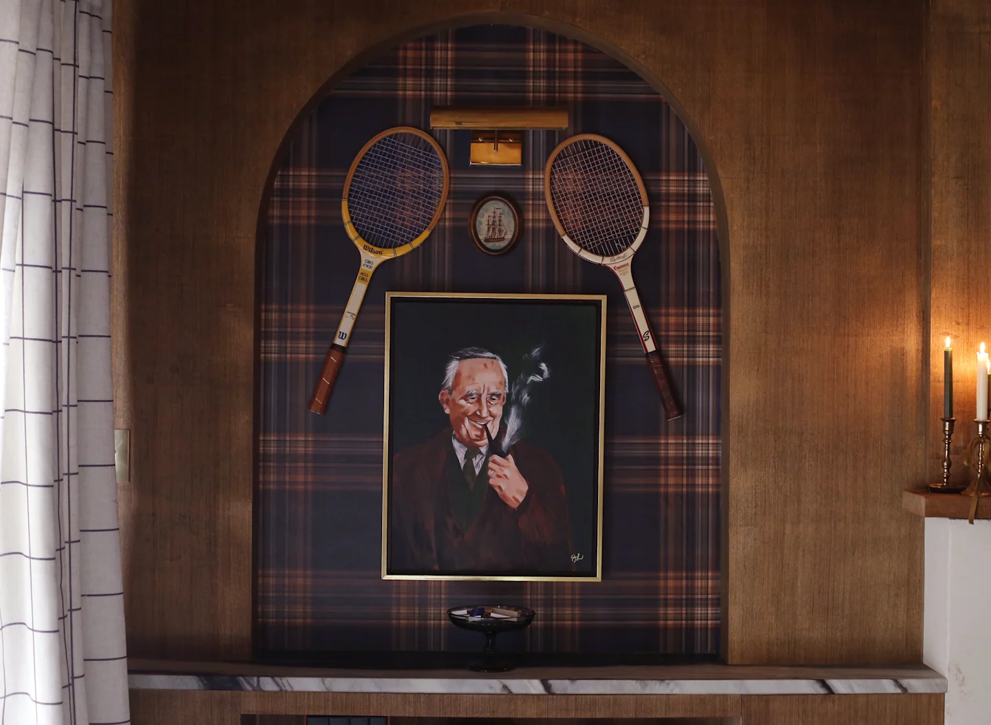 Living area with plaid wallpaper inside an arched wall shelf.