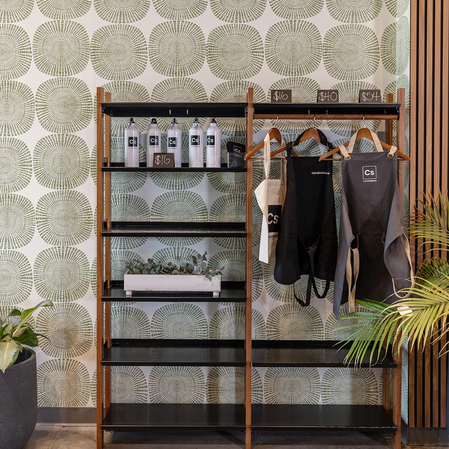Shelf at Candle Science office with geometric wallpaper behind it.