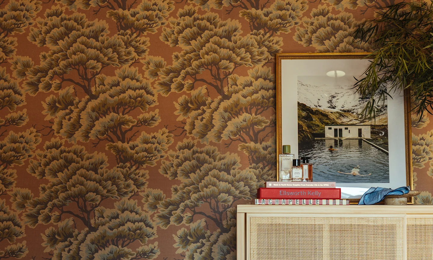 Bedroom with mauve tree wallpaper.