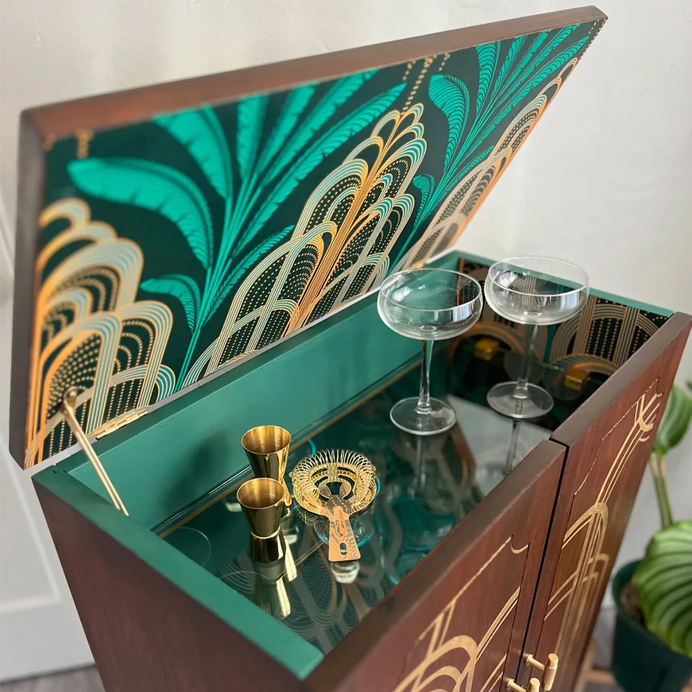 Cocktail cabinet with art deco fountain wallpaper on the inside.