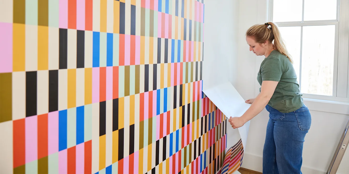 Person removing peel and stick wallpaper.