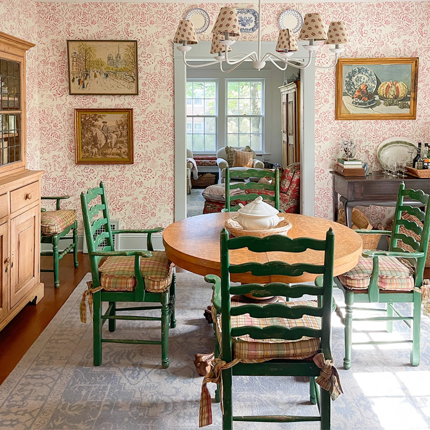 Cottage style dining room with red and cream floral wallpaper.