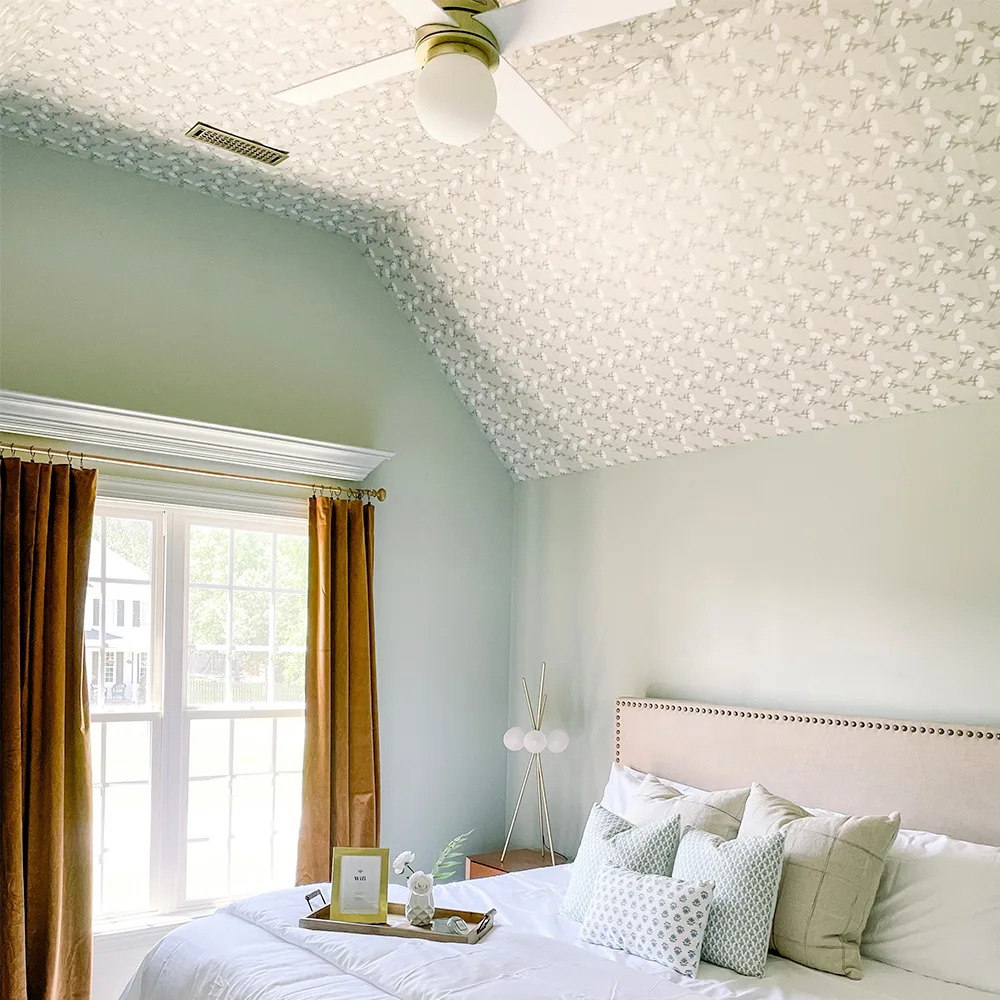 Bedroom with sage green bud wallpaper on the ceiling.