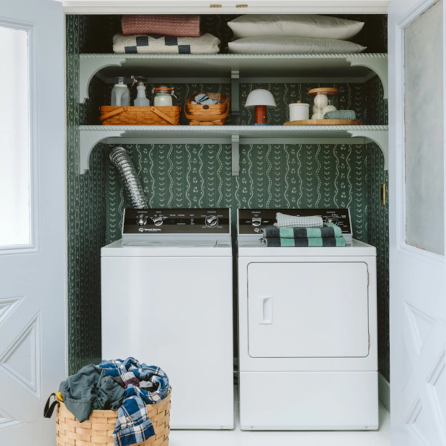 Pine green striped wallpaper in a laundry closet.