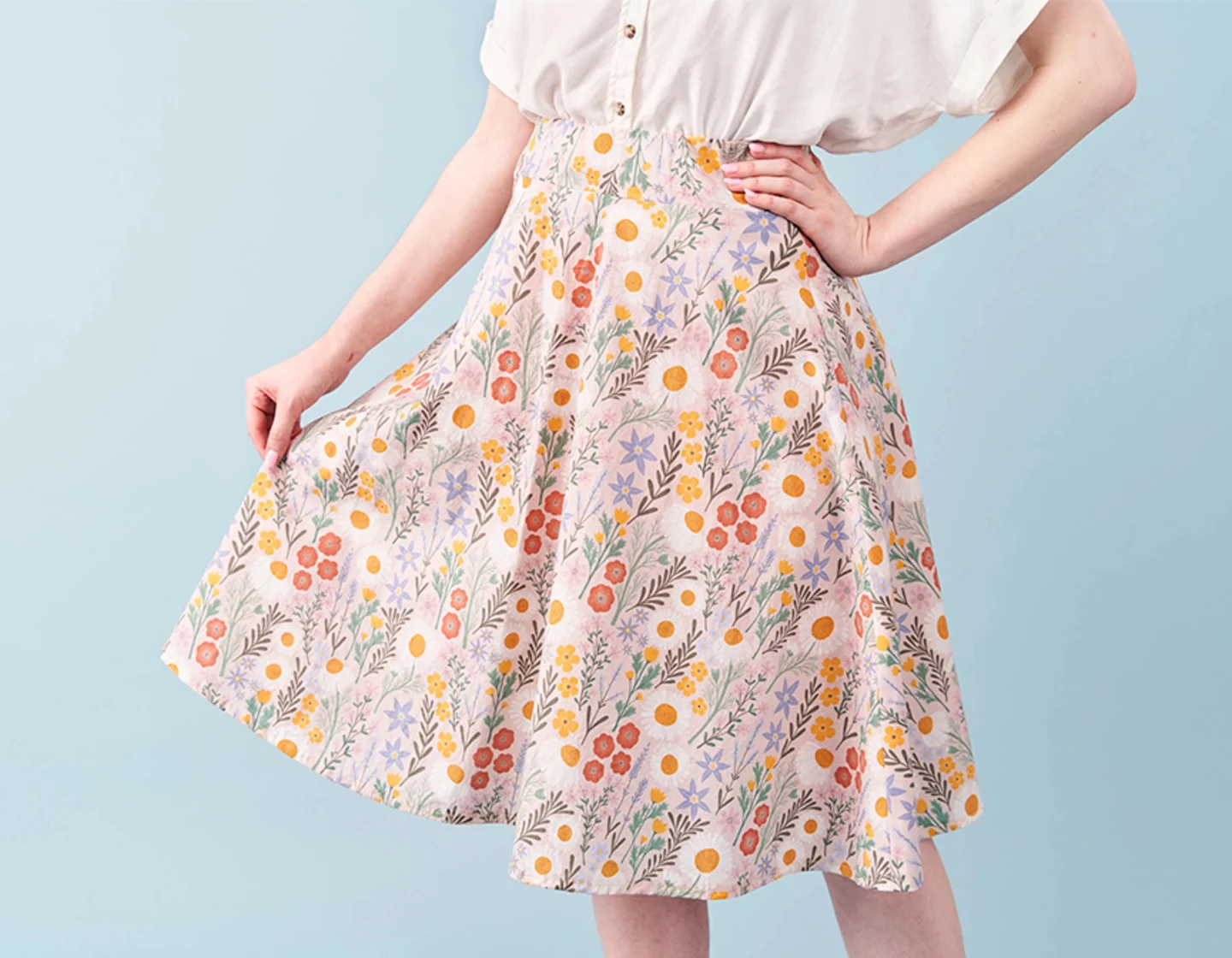 Woman posing in pink spring floral skirt.