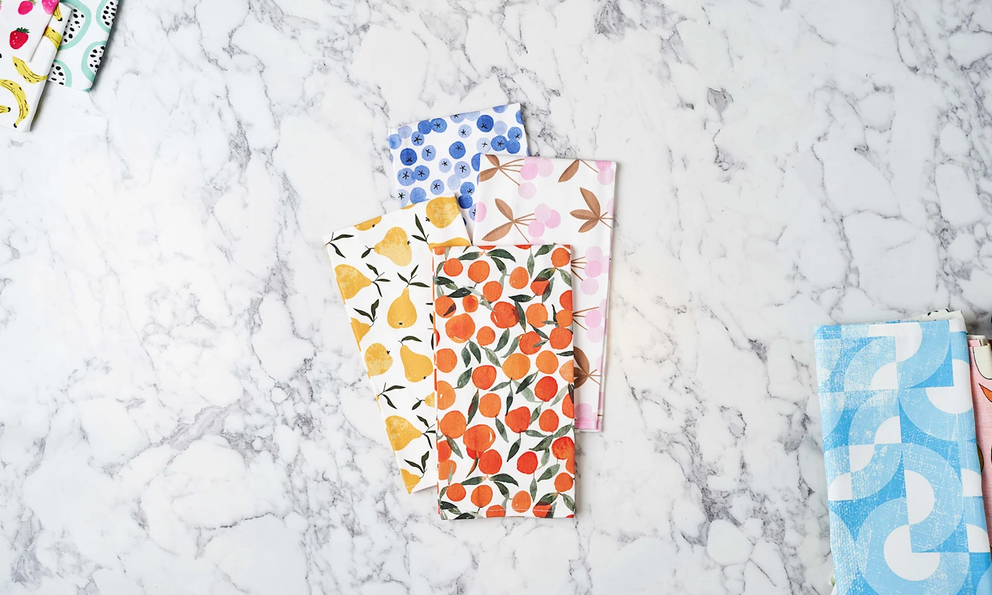 Colorful fruit-themed tea towels on counter.
